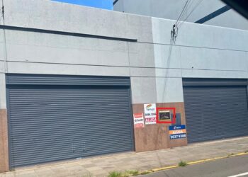 Recado colocado entre os adesivos das imobiliárias indica o novo endereço da Jaque Colchões