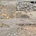 Buracos, crateras, pedras soltas, entulho... Cenário em rua no bairro Operário.