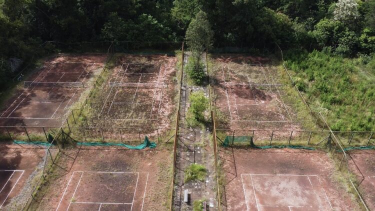 Um cenário triste e decadente: quadras de tênis arruinadas pelo tempo