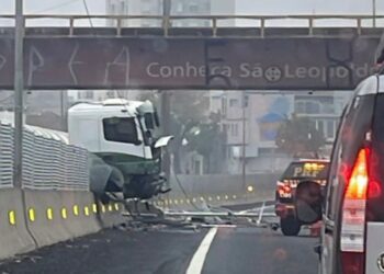 Caminhão está preso no muro central da BR-116