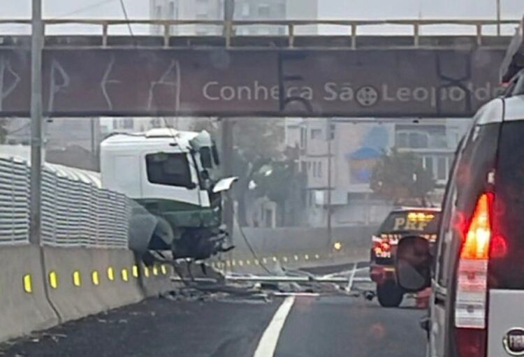Caminhão está preso no muro central da BR-116