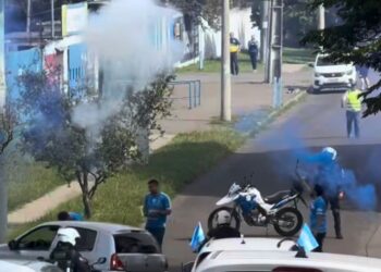 Torcedores soltando fogos de artifício ao lado de guardas municipais. Reprodução