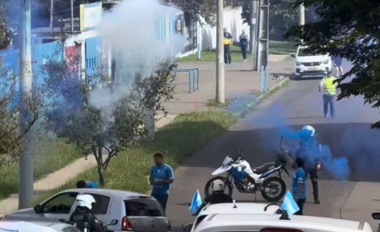 Torcedores soltando fogos de artifício ao lado de guardas municipais. Reprodução