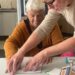 Voluntário e aluna cega em aula de experimentação tátil e sensorial das dimensões não visíveis do papel. Dora Lampert/Divulgação