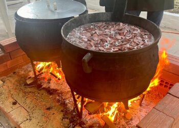 Feijoada é preparada por voluntários em grandes caldeirões